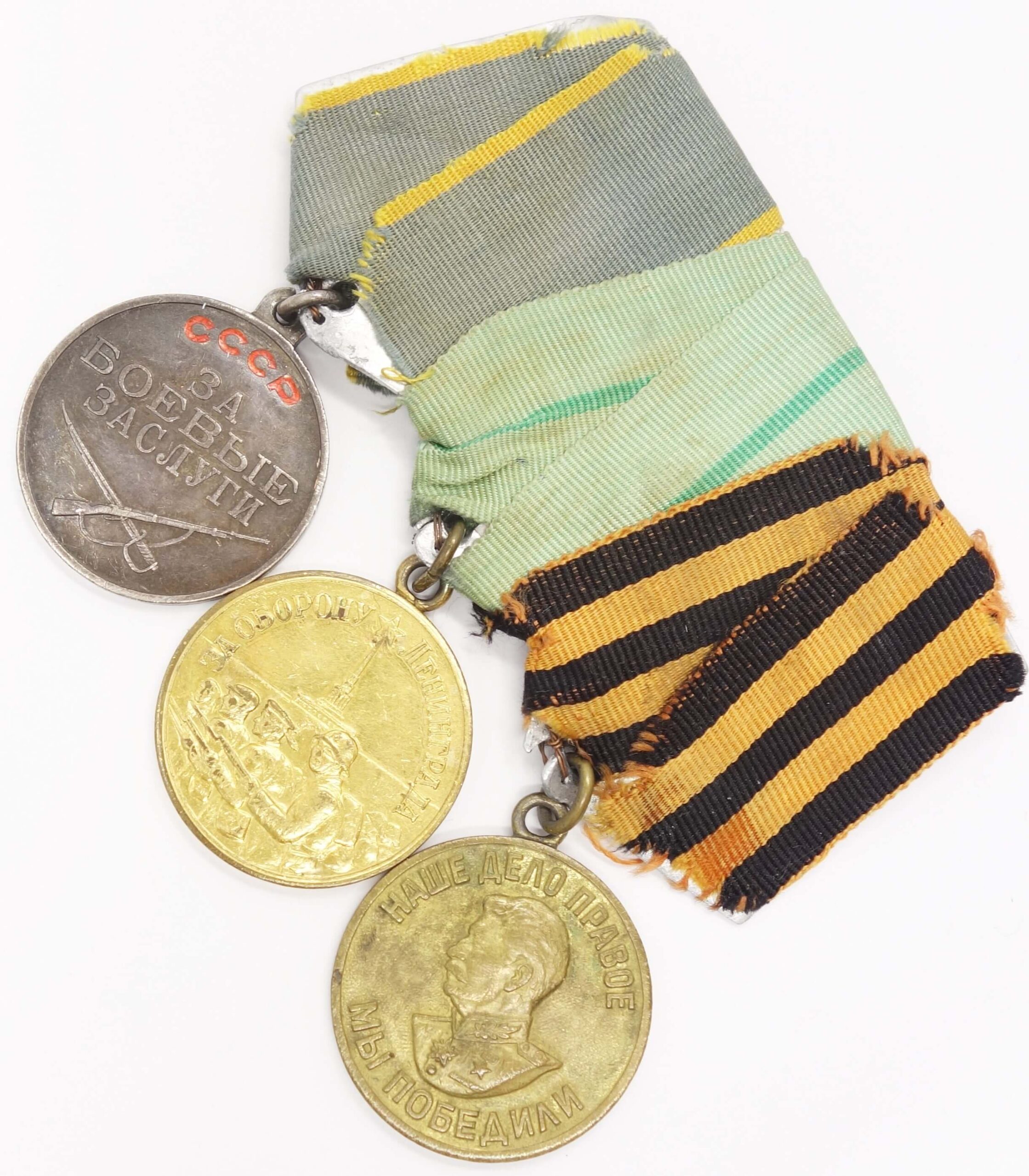 Group of Soviet medals consisting of a medal for Combat Merit #2833606, for the Defense of Leningrad and a Victory over Germany